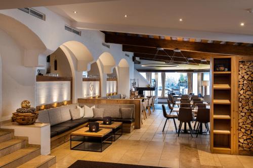 a restaurant with a couch and tables and a bar at Posthotel Pfunds in Pfunds