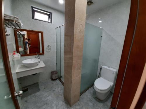 y baño con aseo, lavabo y espejo. en Hotel Phú Sĩ, en Ho Chi Minh
