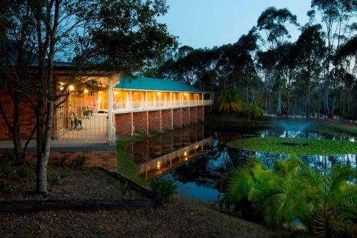 a building next to a lake at night at Golf Club Motor Inn Wingham in Wingham