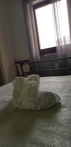 a white pillow on a bed with a window at La Villa in Arco