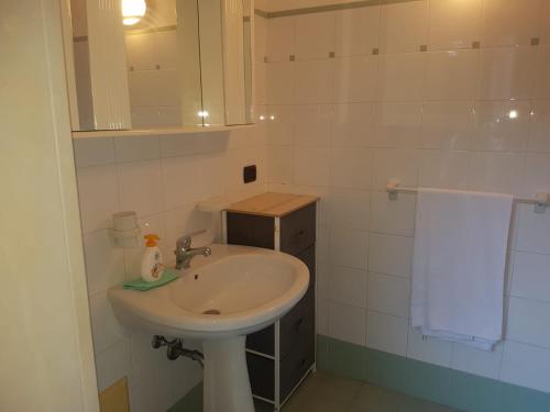 ein weißes Badezimmer mit einem Waschbecken und einem Spiegel in der Unterkunft villa relax sul mare in Gallipoli
