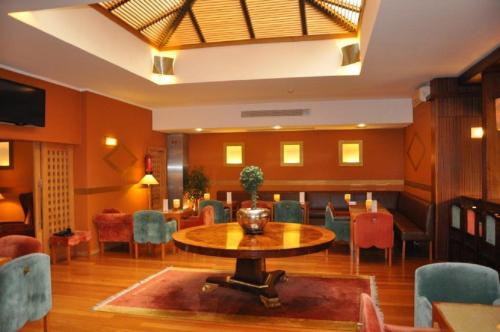 a dining room with a table and chairs and a table at Hotel Central Parque in Maia