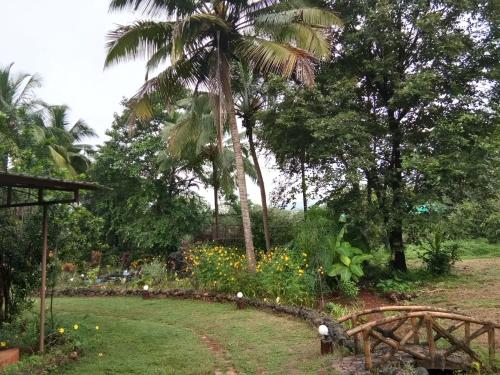 a garden with a palm tree and flowers at THE ENCHANTING NEST in Borim