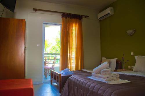 una camera con due letti e una finestra con asciugamani di Hotel Barracuda a Sárti