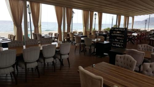 a restaurant with tables and chairs and the ocean at Granada City Alanya Luxury Appartment 800м от пляжа Клеопатра in Alanya