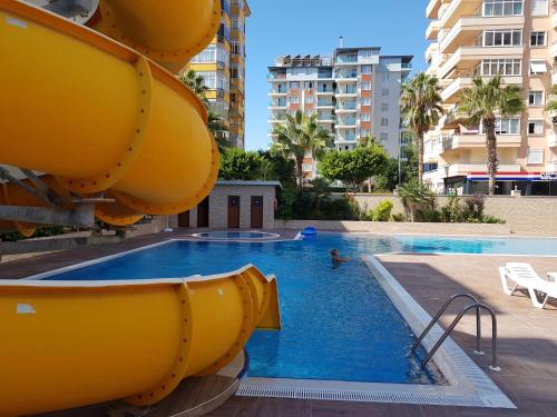 a swimming pool with a slide in a building at Granada City Alanya Luxury Appartment 800м от пляжа Клеопатра in Alanya