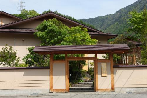 a house with a gate and stairs in front at Keiryuso Siorie in Matsumoto
