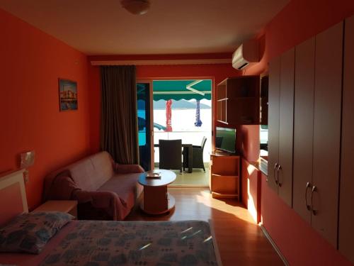 a room with a bed and a living room with a couch at Apartments Kocak in Blace