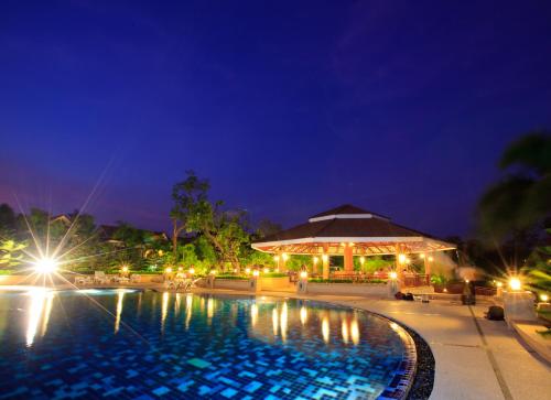 a resort swimming pool at night with lights at Chawalun Resort in Don Tum
