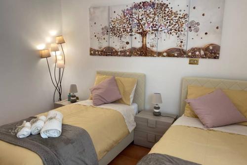 um quarto com duas camas e um quadro na parede em Casa Vacanze Antico Cassaro em Palermo