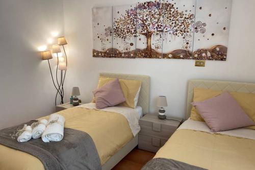 a bedroom with two beds and a painting on the wall at Casa Vacanze Antico Cassaro in Palermo
