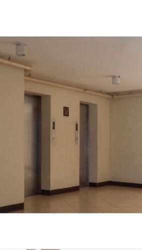 an empty room with two doors and a wooden floor at San Remo Oasis SRP Cebu in Cebu City