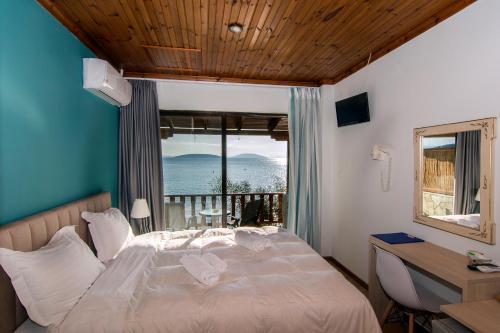 a bedroom with a bed with a view of the ocean at Poseidon Apartments in Tolo