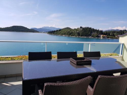 a table and chairs on a balcony with a view of the water at Apartments Kocak in Blace
