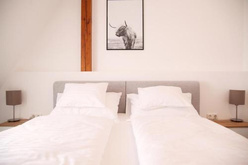 two beds in a room with a picture of a bull at Haus56 in Podersdorf am See