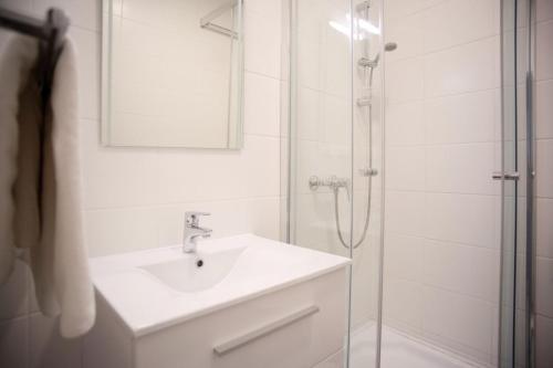 La salle de bains est pourvue d'un lavabo et d'une douche avec un miroir. dans l'établissement Haus56, à Podersdorf am See