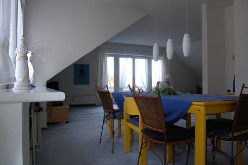 ein Esszimmer mit einem gelben Tisch und Stühlen in der Unterkunft Komfortferienwohnung in ruhiger Lage mit 128qm in Grömitz in Grömitz