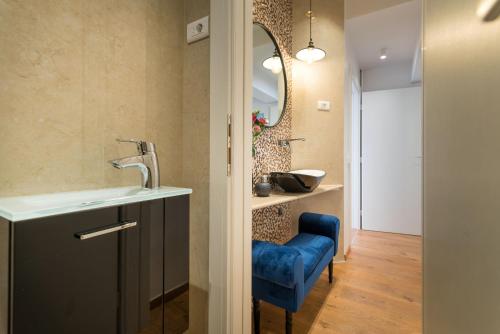 ein Badezimmer mit einem Waschbecken und einem blauen Stuhl in der Unterkunft Villa Biston in Baška Voda