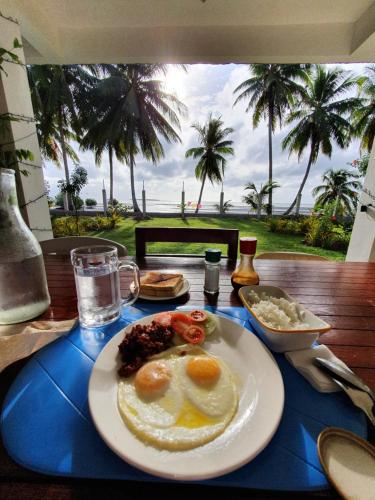 a plate of breakfast food on a table with a view at Chilly Beach Resort Palawan in Aborlan