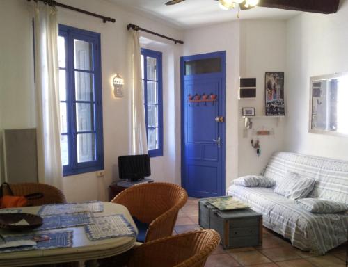 ein Wohnzimmer mit einem Sofa und einer blauen Tür in der Unterkunft CHARME a 20 m de la plage centre village in Collioure