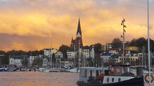 a boat is docked in a harbor with a city at FeWo Auszeit in Harrislee