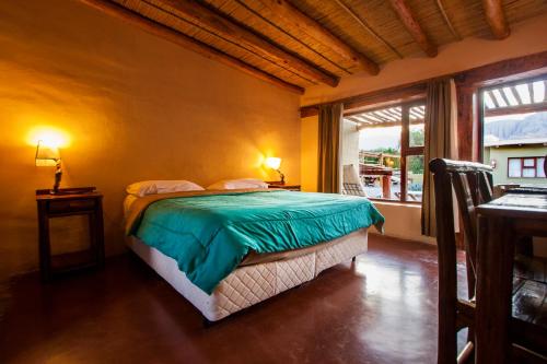 a bedroom with a bed in a room with a window at Alas del Alma in Tilcara