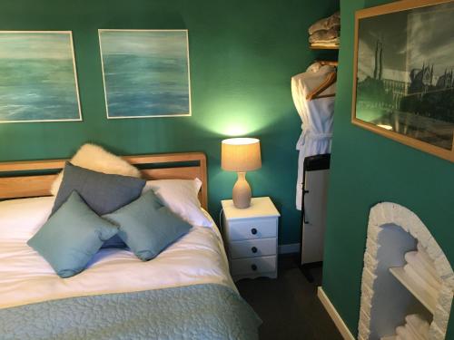 ein Schlafzimmer mit einem Bett und einer grünen Wand in der Unterkunft Bright Moments Holiday Home in Beverley