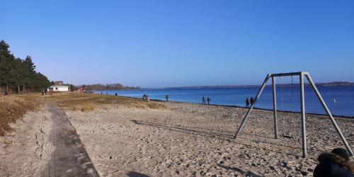 a swing set on a beach next to the water at FeWo Auszeit in Harrislee