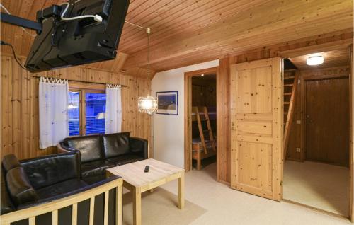 a living room with a black leather couch and a table at Amazing Home In Sysslebäck With Wifi in Sysslebäck
