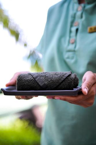 a man is holding a black phone in his hands at Coco de Mer Hotel and Black Parrot Suites in Grand'Anse Praslin