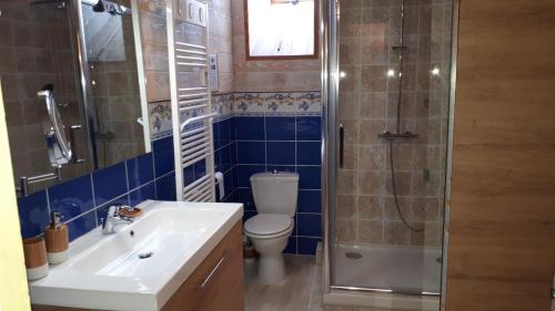 a bathroom with a toilet and a sink and a shower at Le BOCAGE in Sartilly