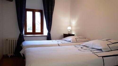 two twin beds in a bedroom with a window at Le BOCAGE in Sartilly