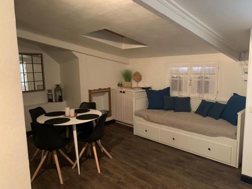 - une chambre avec un lit doté d'oreillers bleus et d'une table dans l'établissement Le Petit Hameau de Chantilly - Studio 4 pers Chic et Charme au Coeur de Chantilly - Classé 3 étoiles, à Chantilly