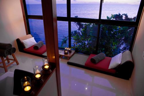 a room with two red couches and a view of the ocean at Coco de Mer Hotel and Black Parrot Suites in Grand'Anse Praslin