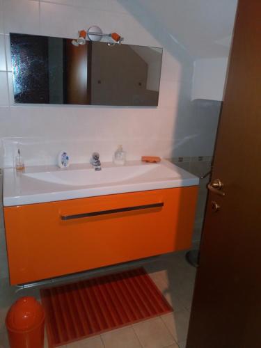 a bathroom with an orange sink and a mirror at Tana per gli ospiti in Terni