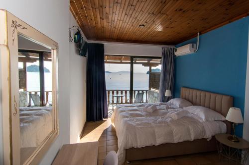 a bedroom with two beds and a view of the ocean at Poseidon Apartments in Tolo