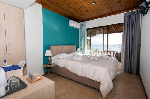a bedroom with a bed with a view of the ocean at Poseidon Apartments in Tolo