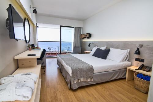 a bedroom with a bed and a desk and a television at Blue Sky City Beach Hotel in Rhodes Town