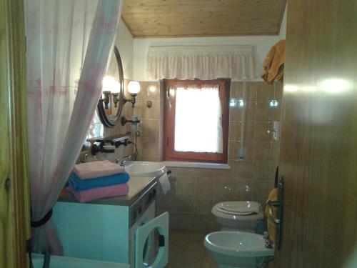 a bathroom with a sink and a toilet and a window at Mansarda in montagna in Abetone