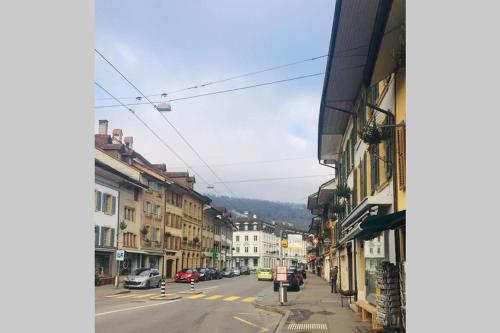 a city street with cars parked on the road at Joline private guest apartment downtown Nidau in Nidau