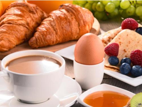 a table with a cup of coffee and croissants and fruit at La Villa in Arco