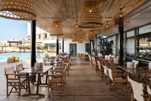 een restaurant met tafels en stoelen en een zwembad bij Blue Sky City Beach Hotel in Rhodos-stad