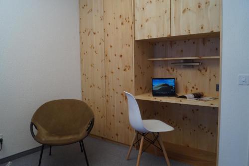 a room with a desk with a computer and a chair at Ferienapartment Davos in Davos