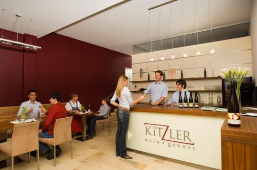 a group of people standing at a bar in a restaurant at Winzerhaus Kitzler in Rohrendorf bei Krems