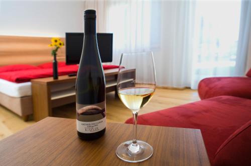 una botella de vino y una copa en una mesa en Winzerhaus Kitzler en Rohrendorf bei Krems