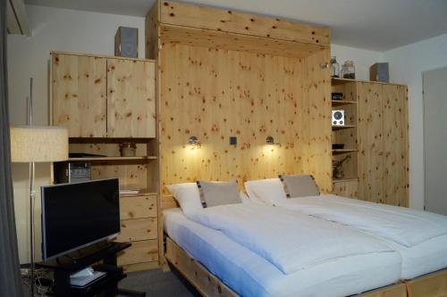a bedroom with a large bed and a television at Ferienapartment Davos in Davos