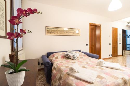 een slaapkamer met een bed en een vaas met bloemen bij Rialto Dream - Wifi in Venetië