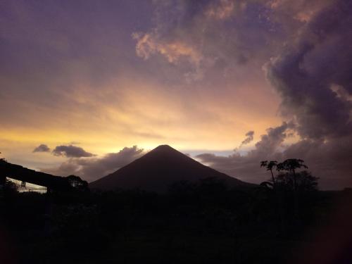 a silhouette of a mountain with a sunset in the background at Finca Montania Sagrada in Mérida