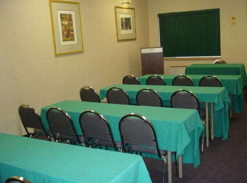 a classroom with blue tables and chairs and a chalkboard at America's Best Value Inn Phillipsburg in Phillipsburg