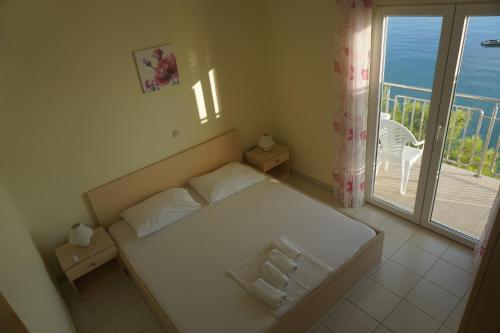 a small bedroom with a bed and a balcony at Apartments and Rooms Kod Mate in Tribanj-Krušćica